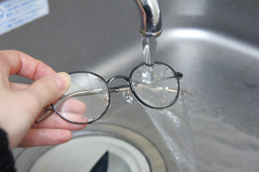 水道の蛇口でメガネを洗っている写真